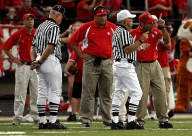 Highschool football officials exhibiting variety of body language postures.