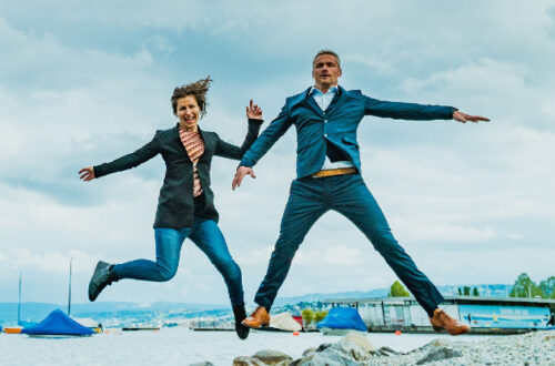 Leaping, energetic, young business Couple, Seaside background